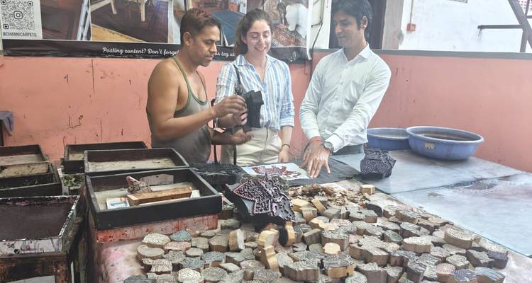 Touristes apprenant l'impression traditionnelle sur bois dans un atelier d'artisan.