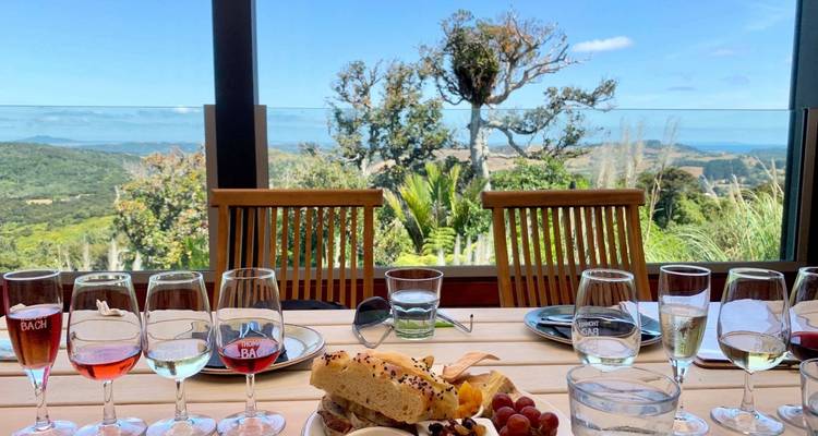 Una mesa puesta con copas de vino y comida con vista a un paisaje escénico.