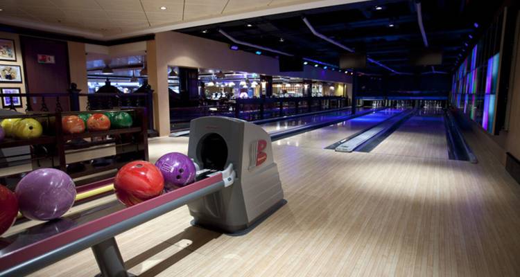 Bolera con varias pistas y bolas de boliche coloridas.