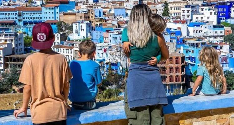 Familie betrachtet die blau gestrichenen Gebäude einer Stadt.