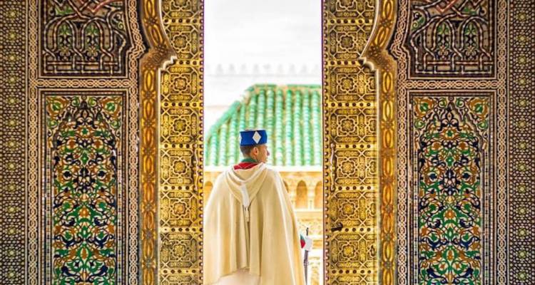 Aufwendig verzierte Tür mit einer Person in traditioneller Kleidung