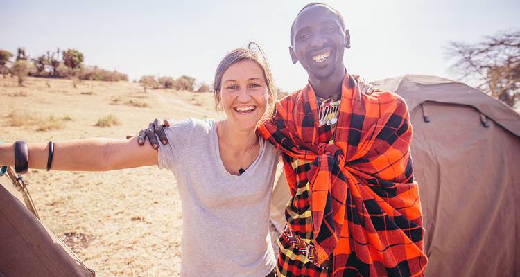 Twee mensen, waaronder een lokale bewoner, die glimlachen en samen poseren.