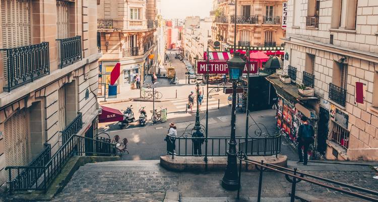 Parisian street leading down from Montmartre with cafes and stairs.