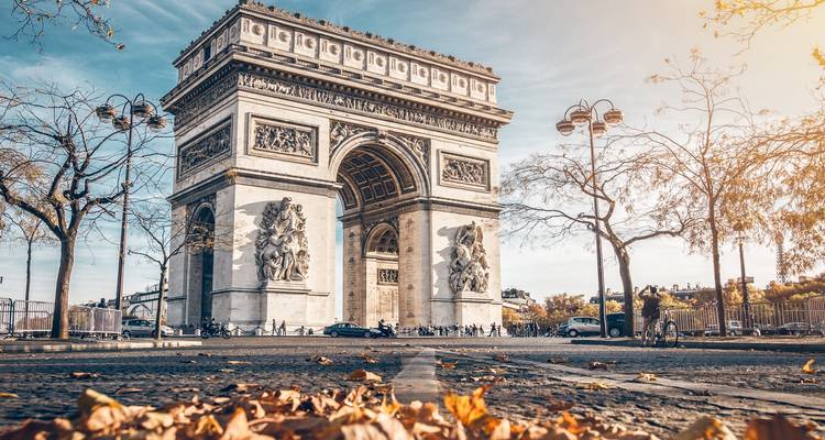 Célèbre arc monumental avec des feuilles d'automne au premier plan.
