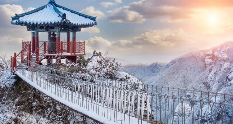 Prieel op een besneeuwde berg met de ondergaande zon.