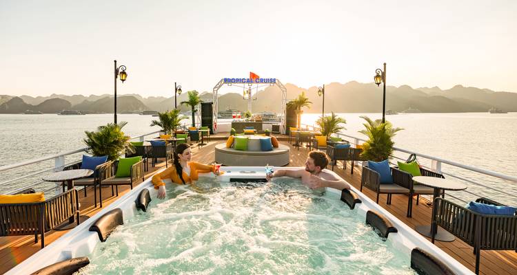 Couple se détendant dans un jacuzzi sur un bateau de croisière au coucher du soleil.