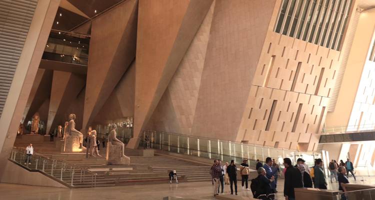 Inneres eines Museums mit Statuen und umherlaufenden Menschen.