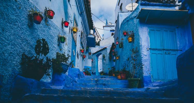Ruelle peinte en bleu avec des lanternes décoratives à Chefchaouen.