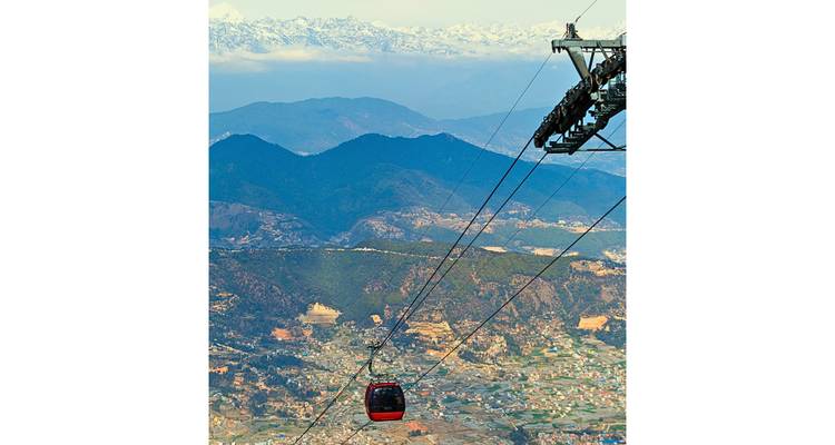 Cable car with mountain and city view in the background.
