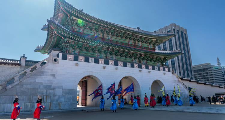 Une porte historique coréenne avec des gardes traditionnels en uniforme.