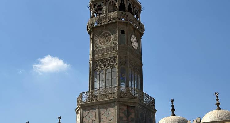 Klokkentoren met ingewikkelde gravures en een blauwe lucht.