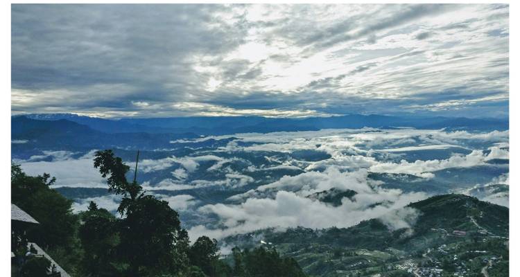 A panoramic view of mountains with clouds at sunrise