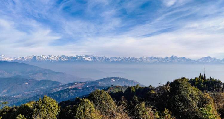 Mountain range with clear skies and forested hills.