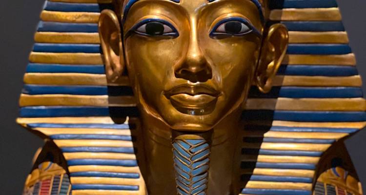 Gros plan d'un masque de pharaon doré avec des détails complexes.