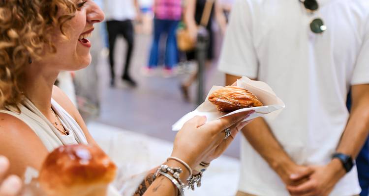Woman happily holding a powdered pastry.