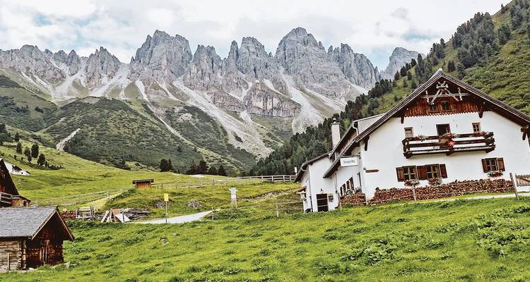 Paysage de vallée de montagne avec maisons alpines traditionnelles.