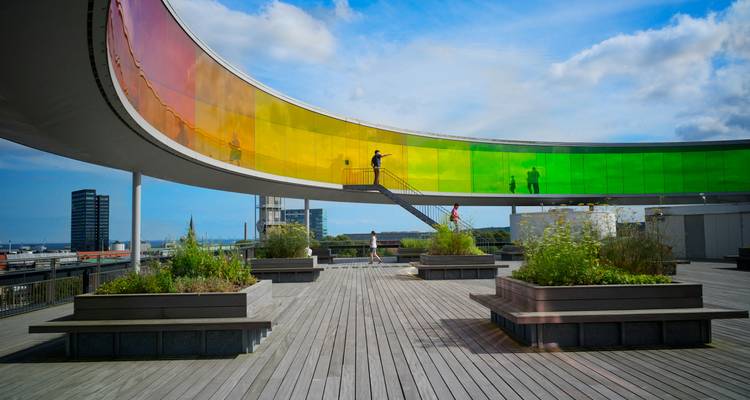 A modern art structure with a rainbow walkway on a rooftop.