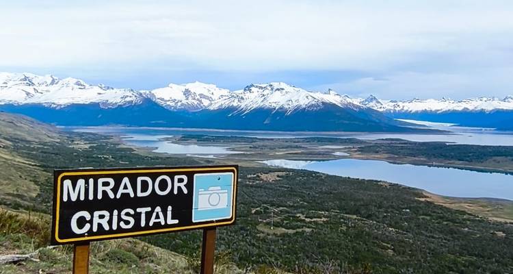 Mirador Cristal sign with scenic view of mountains and lakes.