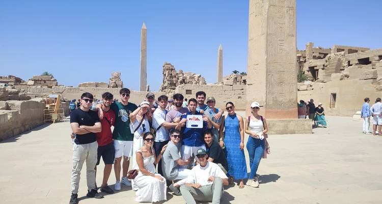 A group of tourists posing in front of Karnak temple.