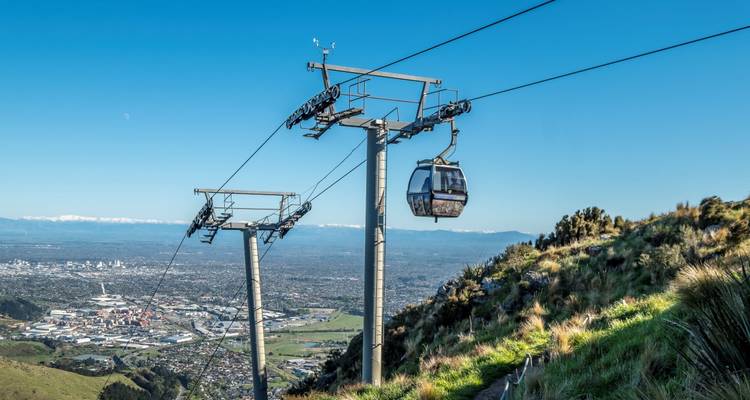 Téléphérique surplombant une ville et des montagnes.