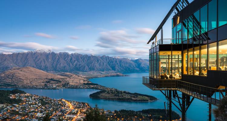 Vue surélevée de Queenstown avec un restaurant donnant sur un lac et des montagnes.
