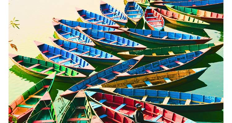 Colorful boats arranged on water viewed from above.