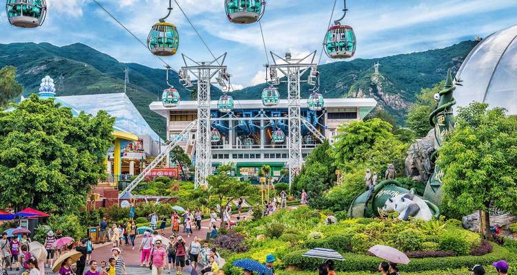 A vibrant theme park with cable cars and people enjoying rides.