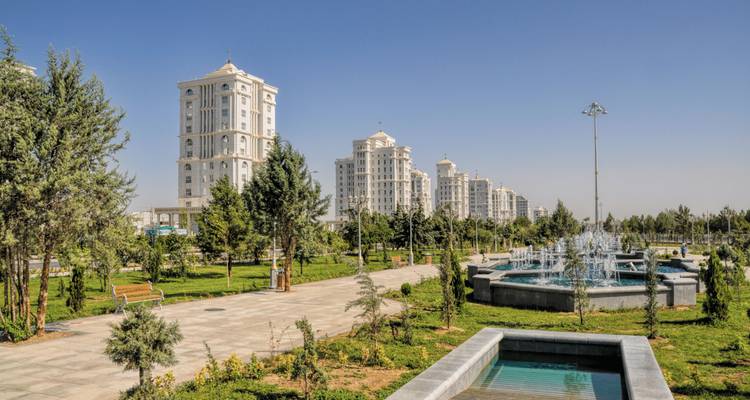 Parc urbain moderne avec fontaines et gratte-ciel.