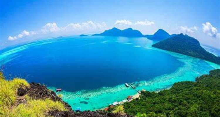 Vue aérienne d'une île tropicale avec des eaux bleues and des montagnes.