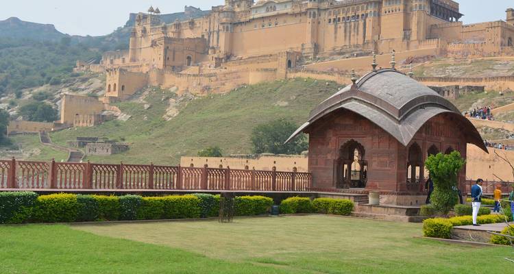 Fort d'Amber avec un petit jardin et deux personnes visibles au premier plan.