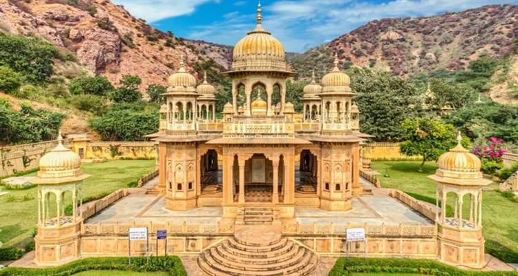 Magnifique temple avec des dômes et des sculptures complexes entouré de collines.
