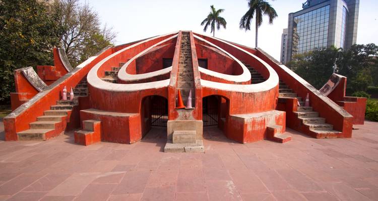 Structure de l'observatoire Jantar Mantar avec des palmiers derrière.