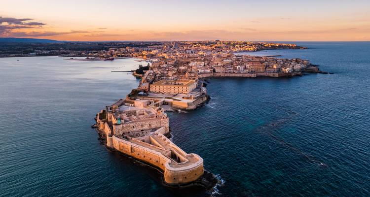 Vue aérienne d'une ville côtière au coucher du soleil.