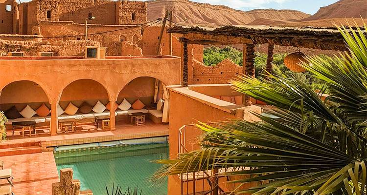 Complexe hôtelier avec piscine dans un cadre pittoresque de montagnes.