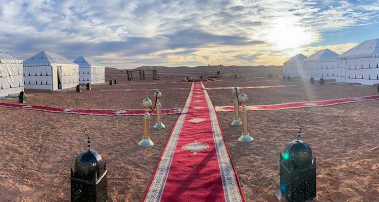 Installation de camp dans le désert avec tentes luxueuses et décoration.