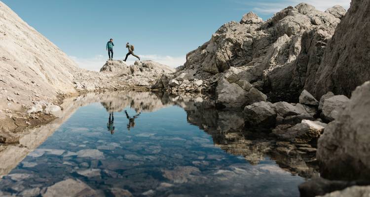Zwei Wanderer auf felsigem Gelände mit Bergblick.