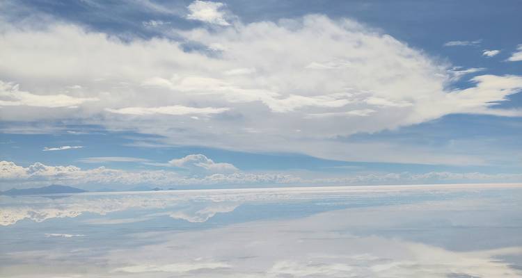 Reflectie van wolken en lucht op een zoutvlakte.