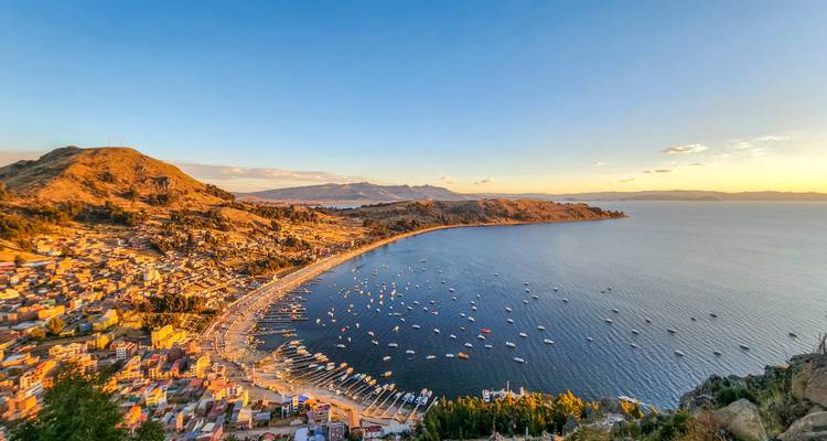 Kustplaats met een zandstrand en boten in een baai.