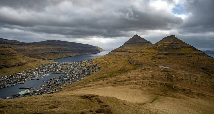 Panoramic view of a coastal town with mountains in the Faroe Islands.