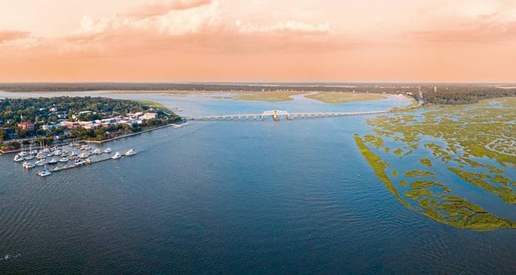 Vue aérienne d'une zone côtière avec pont et bateaux.