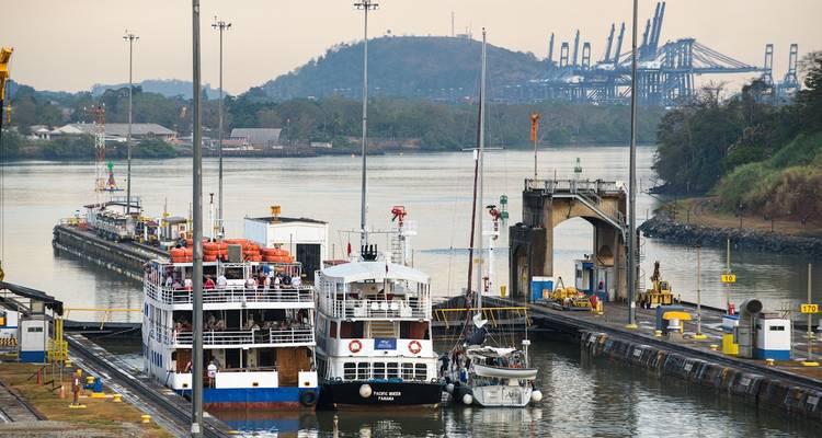 Écluse du canal de Panama avec navires et arrière-plan industriel.