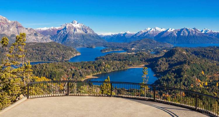 Vue panoramique d'un lac avec des forêts et des montagnes environnantes.