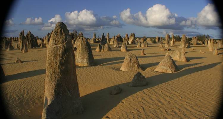 Dramatic rock formations in the desert under a blue sky.