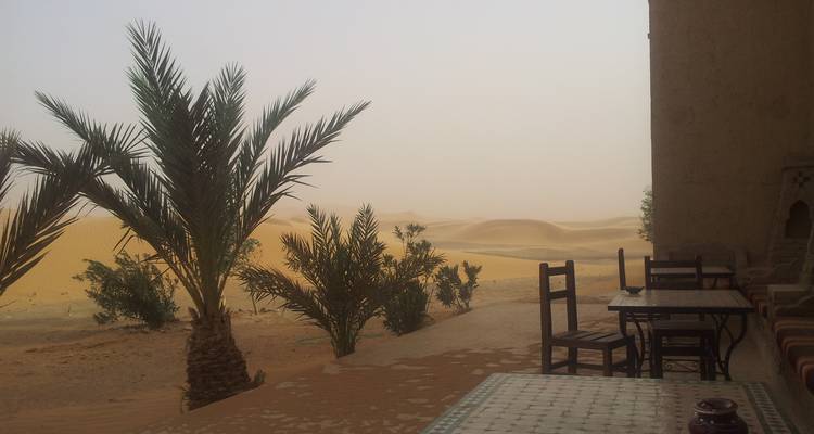 Vue depuis un patio donnant sur des dunes de sable.