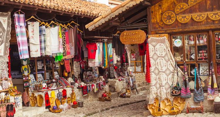 Puesto de mercado que exhibe textiles tradicionales coloridos.
