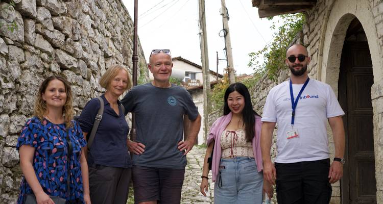 Grupo de turistas parados en una calle estrecha.