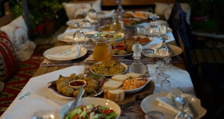 Mesa de comedor al aire libre con varios platos tradicionales.