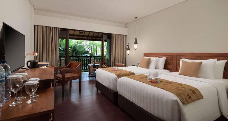 Spacious hotel room with twin beds and a balcony view.