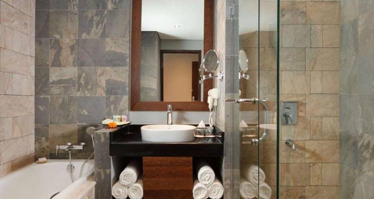 Hotel bathroom with a bathtub, shower, and modern fixtures.