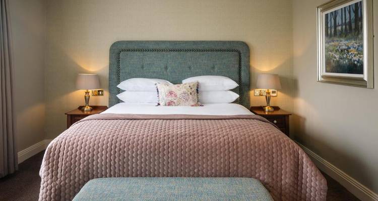 Cozy hotel bedroom with a double bed and warm lighting.